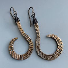 I made these bronze incised curls based on a favorite pair of vintage ethnic earrings.   Black wired caps and niobium wires  complete this tribal fusion design. Unique Adjustable Brass Wrap Earrings, Adjustable Unique Wrap Earrings In Brass, Artisan Brass Hoop Earrings Wire Wrapped, Artisan Bronze Nickel-free Hoop Earrings, Bohemian Metal Wrap Earrings With Ear Wire, Unique Nickel-free Brass Wrap Earrings, Bohemian Copper Wrap Earrings, Bronze Brass Wire Wrapped Hoop Earrings, Hand Forged Bronze Metal Earrings