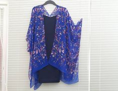 "This versatile kimono cardigan can be worn as a beach cover-up or with a  dress or camisole. Suitable for daywear or eveningwear, the perfect addition to any wardrobe.  Ideal for holidays and travelling, even backpacking as it takes up nearly no room in your travel bag and is light. - Blue Kimono Cardigan  - Wide Sleeves - Draping perfectly - Light weight sheer soft fabric - One size fits most - Floaty fabric - Light and breathable - V neck style at the back *Please note the dress is not includ Blue V-neck Kimono For Spring, Blue Spring Kimono For Daywear, Blue Kimono For Spring Daywear, Blue Kimono For Daywear In Spring, Blue Kimono With Kimono Sleeves For Daywear, Blue Long Kimono For Daywear, Long Blue Kimono For Daywear, Spring Beach Cover-up Shawl, Blue Open Front Kimono For Beach Season