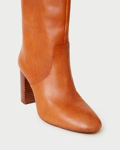 Tall shaft boot with high heel in cognac brown vachetta leather. Padded footbed with gold stamped logo. Almond toe, pulls on. 3.5 inch heel. Size (US) Shaft Height Calf Circumference 5 14.92" 14.49" 5.5 15.08" 14.67" 6 15.24" 14.84" 6.5 15.39" 15.02" 7 15.55" 15.2" 7.5 15.71" 15.37" 8 15.87" 15.55" 8.5 16.02" 15.73" 9 16.18" 15.91" 9.5 16.34" 16.11" 10 16.5" 16.26" 10.5 16.65" 16.48" 11 16.81" 16.61" 11.5 16.97" 16.8" 12 17.13" 16.97" Cognac Leather High Heel Boots, Cognac Leather Heeled Boots With Reinforced Heel, Brown Calf Leather Boots With Sculpted Heel, Cognac Heeled Boots With Leather Lining, Brown Leather Heeled Boots With Sculpted Heel, Elegant Brown Boots With Heel Pull Tab, Classic Brown Boots With Block Heel, Brown Almond Toe Heeled Boots With Sculpted Heel, Chic Cognac Boots For Work