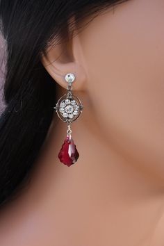 "A great earring for the bridal party or bridesmaids that they can also enjoy wearing after the wedding.  A gorgeous Swarovski crystal dangles from a antiqued silver Swarovski rhinestone filigree flower giving this earring a vintage feel.  They are finished on a post.  It is pictured in clear and ruby but see above for other color choices.  These measure about 1 3/4\" in length." Red Crystal Earrings For Wedding, Elegant Jeweled Crystal Earrings For Wedding, Elegant Jeweled Chandelier Earrings For Wedding, Wedding Cubic Zirconia Jeweled Crystal Earrings, Wedding Clip-on Drop Crystal Earrings, Wedding Jeweled Crystal Clip-on Earrings, Crystal Jeweled Bridal Earrings For Wedding, Crystal Clip-on Earrings With Jewels For Wedding, Crystal Jeweled Clip-on Earrings For Wedding