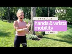 a woman is standing in the grass with her hands and wristbands up to her chest