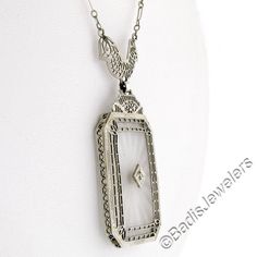 This is a gorgeous and VERY WELL MADE pendant necklace crafted during the art deco period in solid 14k white gold. It features a large, rectangular-shaped, camphor glass panel with cut corners and a stunning diamond set at its center. The pendant displays magnificent etching designs and open filigree work throughout its frame as well as the part that connects to the chain. The filigree work gives this piece its unique look and makes a special statement on this pendant. The lovely diamond is set Art Deco Platinum Jewelry For Evening, Collectible White Gold Diamond Necklace, Rectangular Platinum Jewelry With 17 Jewels, White Art Deco Jewelry For Vintage Events, Art Deco Engraved Jewelry, Art Deco Engraved Jewelry For Vintage Events, Art Deco White Gold Necklace For Evening, Victorian Platinum Jewelry For Formal Occasions, Art Deco Diamond Cut Jewelry For Vintage Events