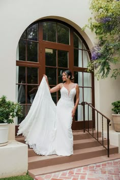 a woman in a wedding dress walking up some steps