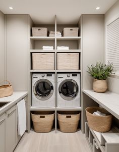 a washer and dryer sitting in a room next to some shelves with baskets