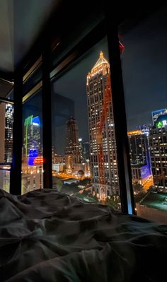 a bedroom with a view of the city at night