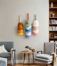 two chairs and a table in a living room with bookshelves on the wall