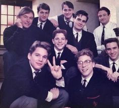 a group of men in suits and ties posing for a photo with one man giving the peace sign