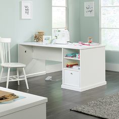 a white desk and chair in a room with light blue walls, wood floors and hardwood flooring