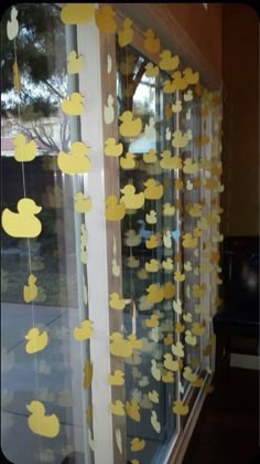 some yellow ducks are hanging from the window