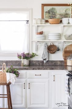 a kitchen with white cabinets and open shelves