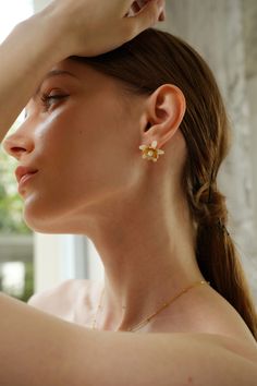 Evoke the essence of spring with the Magnolia Floral Stud Earrings, blooming with timeless elegance. Delicate magnolia blossoms crafted in intricate detail cradle lustrous pearls, creating a captivating floral motif. These earrings are the perfect accessory to elevate any outfit, whether it's a romantic date night or a casual brunch with friends. Pair them with a floral sundress and sandals for a fresh and feminine look, or with a tailored blazer and trousers for a sophisticated touch to your wo Feminine Flower-shaped Jewelry With Matching Earrings, Spring Wedding Pearl Drop Jewelry, Feminine Flower Earrings For Pierced Ears, Feminine Flower Earrings, Feminine Flower Charm Earrings, Feminine Jewelry With Matching Earrings For Spring, Elegant Spring Flower Earrings, Feminine Pearl Flower Earrings, Feminine Flower Drop Earrings With Pearl Drop