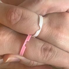 a woman's hand with a pink band on it