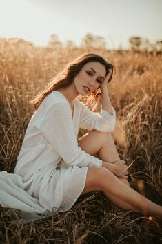 a woman is sitting in the middle of a field