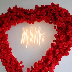 a heart - shaped wreath with the word mr and mrs spelled in white neon letters