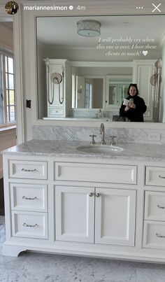 a woman taking a selfie in front of a bathroom mirror with the reflection of her