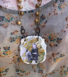 a necklace with an image of a bear and flowers on it, hanging from a gold chain