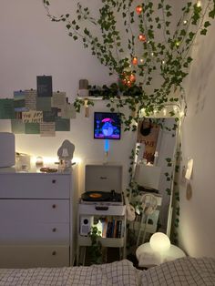 a bed room with a tv and a tree in the corner on the wall next to it