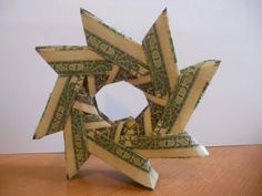 an origami star made out of dollar bills on a wooden table with white background