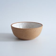 a white and brown bowl sitting on top of a table