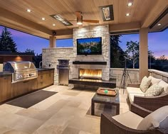 an outdoor living room with fireplace and grill