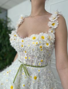 a woman in a white dress with daisies on it