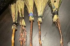 four brooms are lined up on the floor