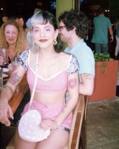 a woman sitting on top of a wooden bench next to a man