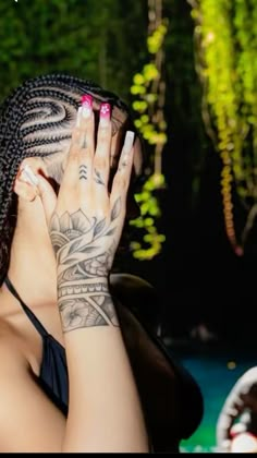 a woman with tattoos covering her face and hand over her eyes, looking into the distance