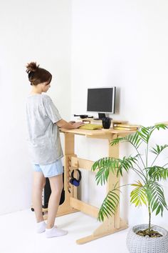 a woman standing in front of a computer desk