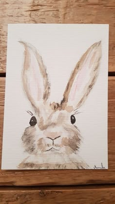 a painting of a rabbit's face is shown on a piece of wooden planks