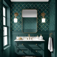 a bathroom with dark green walls and gold accents on the mirror above the double sink