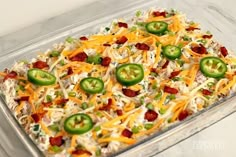 a casserole dish with cheese, bacon and jalapenos on top