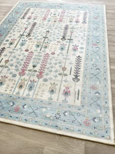 a blue and white rug with flowers on the bottom is laying on a wooden floor