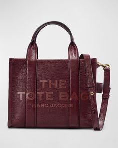 The Marc Jacobs logo-embossed tote bag in calf leather Flat top handles, 4" drop Removable, adjustable crossbody strap, 51", 24"  drop Zip top closure Exterior, side strap accent Interior, slip pocket Approx. 8"H x 10.25"W x 5.25"D Item weighs approx. 24 oz/0.68 kg. "Traveler" is imported Everyday Calf Leather Bag With Logo, Tan Leather Bag With Logo Hardware, On-the-go Leather Shoulder Bag With Logo Hardware, Marc Jacobs Logo, Mini Tote Bag, Mini Tote, Flats Top, Leather Flats, Leather Mini