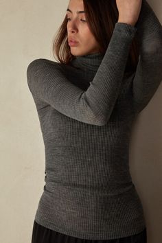 Long-sleeve high-neck tubular top made from a wool-silk blend. Fitted Elegant Merino Wool Tops, Elegant Fitted Merino Wool Tops, Fine Knit High Neck Merino Wool Top, Stretch Merino Wool Turtleneck Top, Fine Knit Merino Wool High Neck Top, Chic Winter Merino Wool Top, Elegant Merino Wool Turtleneck Top, High Neck Merino Wool Tops For Layering, Merino Wool Turtleneck Top