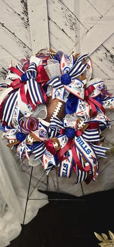 a football wreath is hanging from the ceiling with red, white and blue ribbons on it