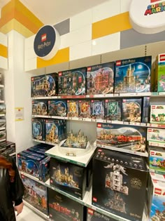 a woman is looking at legos on display in a toy store with other toys