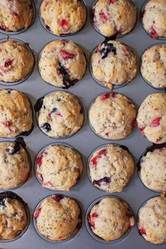 muffins with blueberries and cranberries are in the baking pan, ready to be baked