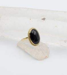 Large mid century onyx ring in 14k yellow gold. This ring is in lovely condition and has a big impact. The onyx is a oval cut set in a rope frame. The under gallery has a lovely basket setting. Gemstone: Oval Cabochon Black Onyx Measurements: 20 x 15 mm Width: 23.7 x 18.6 mm / 1.1 - 2.5 mm wide shank / 10.7 mm high off finger Metal: 14k yellow Markings: 585 Finger Size: 5.75 (with sizing balls to prevent from rotating) Weight: 7.6 grams Circa: 1960's Condition Rating: 8 (sizing balls were added, Heirloom Black Enamel Oval Ring, Oval Onyx Signet Ring With Gemstone, Gold Oval Onyx Rings, Oval Cabochon Onyx Ring, Oval Onyx Cabochon Ring, Oval Onyx Ring With Cabochon, Vintage Onyx Ring, Onyx Signet Ring, Rope Frame