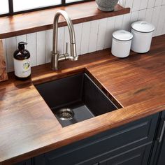 a kitchen sink sitting under a window next to a counter