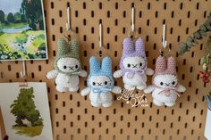 four crocheted stuffed animals hanging from hooks on a pegboard in a store