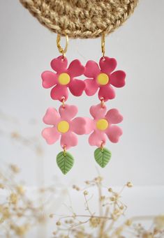 Add a touch of whimsy and elegance to any outfit with these stunning Pink Flowers Earrings. These earrings feature a beautiful cluster of delicate pink flowers that dangle gracefully from a gold-tone earring hook. Handcrafted with care, these earrings are made from high-quality materials, ensuring durability and longevity. The flowers are made from lightweight polymer clay and are adorned with delicate green leaves to give them a unique and eye-catching look. Measuring approximately 3 inches lon Dainty Flower Earrings For Spring Wedding, Dainty Spring Flower Earrings For Wedding, Dainty Spring Wedding Flower Earrings, Whimsical Pink Earrings With Flower Charm, Whimsical Earrings With 3d Flowers For Gift, Handmade Feminine Flower Earrings, Handmade Feminine Flower Shaped Earrings, Handmade Feminine Dangle Flower Earrings, Whimsical Handmade Flower Earrings For Gift