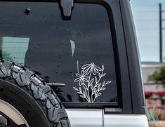 a white flower sticker on the side of a truck's window is shown