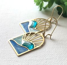 Beautiful handmade blue ocean wave earrings with sun rays! These little windows are truly unique with each being one of a kind. I created these by experimenting with different colorant and resin to produce stunning transparent color shades, giving them a wonderful mosaic, stained glass look. The effect is so eye catching! Perfect for that destination wedding, summer outfit, or tropical vacation.  A wonderful gift gift for yourself or the ocean lover! 🌿 *EACH PAIR of earrings will be UNIQUE in color shading, placement and/or intensity. Water may have greenish hues, varied blue hues.  🌿 100% handcrafted by me! **Each pair is made to order. 🌿 Earring hooks are hypoallergenic kidney style, gold over stainless steel. 🌿 Total earring length with hooks is 2 inches. 🌿 Earring arch window is 3 Blue Artistic Design Drop Earrings, Blue Ear Wire Earrings For The Beach, Unique Blue Earrings With Artistic Design, Artistic Handmade Beach Jewelry, Ocean-inspired Blue Earrings With Ear Wire, Nickel-free Blue Earrings For Vacation, Artsy Blue Teardrop Earrings, Blue Earrings For Vacation, Artistic Blue Jewelry For Summer