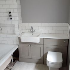 a white toilet sitting next to a sink and a bath tub in a bathroom under construction