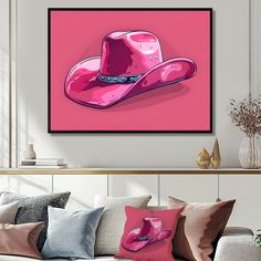 a pink cowboy hat on a pink background in a living room with sofa and coffee table