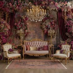 a living room with couches, chandelier and flowers on the wall behind it