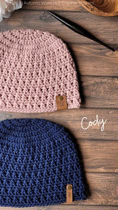 two crocheted hats sitting next to each other on top of a wooden table