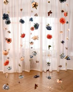 the curtains are decorated with paper flowers and butterflies in various colors, shapes and sizes