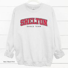 Shelton Dance Team Shirt If you’re the school spirit type, this Shelton High School Dance Team Shirt is for you! Get ready to show your SHS pride with this comfortable and stylish shirt, perfect for cheering on your favorite dance squad. Go Climbers!! Choose T-shirt, Crewneck Sweatshirt or Hoodie Sweatshirt. Super comfy unisex sizes. Our shirts, hoodies, and sweatshirts are crafted with comfort and quality in mind. Made from premium materials, they are soft, durable, and perfect for everyday wea Sporty Long Sleeve Tops For College Events, Sporty Letter Print Tops For College Events, Sporty Tops With Letter Print For College Events, Sporty Stretch Tops For School, Cotton Tops For College Events, Sporty Tops With Team Name For College Events, White Varsity Top For College Events, Varsity Tops With Team Name For College Events, Sporty Cheerleading Tops With Name Print